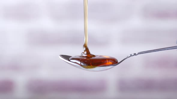 Close Up of Fresh Honey Dropping on a Spoon