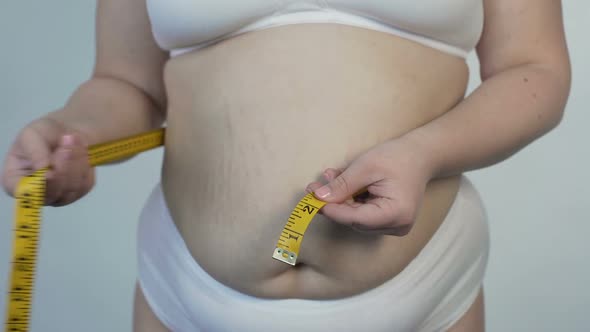 Inspired Woman Taking Stomach Measurements, Overweight and Dieting, Healthcare