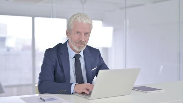 Old Businessman Looking at the Camera and Smiling