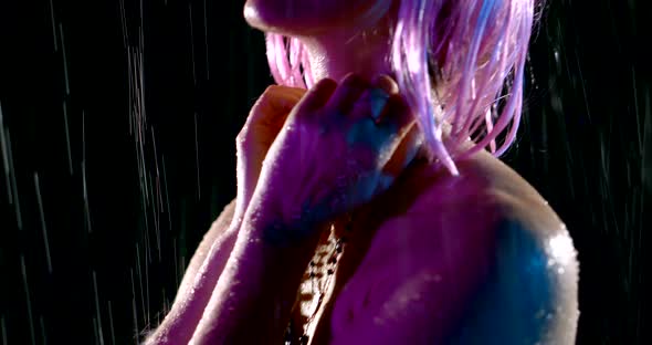 Portrait in Profile of a Woman with Pink Hair in the Rain in the Dark