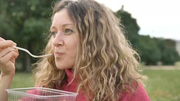 Woman Eating a Sweet Dessert with a Disposable Fork From a Plastic Container, Food Take-away in