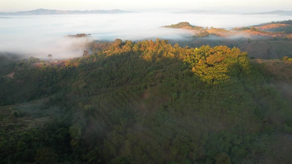 4K Scenic flight over beautiful mountain scape with bright sky and clouds