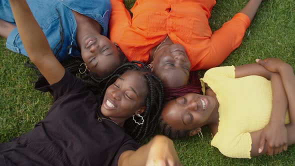 Overhead View of Cheerful Black Family Lying on Grass in Circle