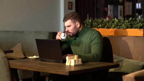 Pensive Freelancer Working on a New Project in the Cafe. A Serious Businessman with a Thoughtful