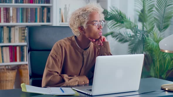 African American Woman in Eyeglasses Working on Computer at Modern Home Office