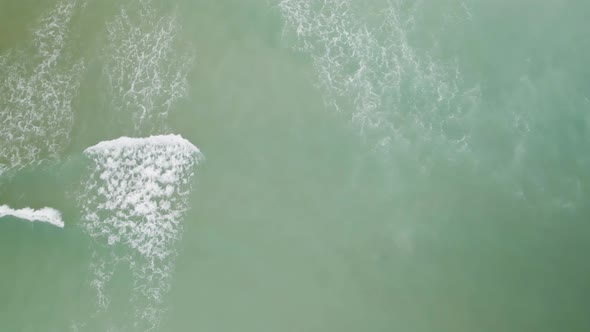 Overhead aerial view of waves rolling towards beach