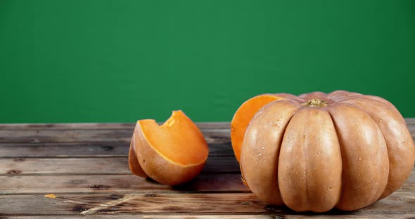 Whole and a Piece of Fresh Pumpkin on Wooden Table.