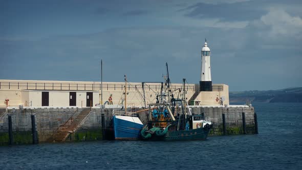 Fishing Boat Moored By Pier And Small Lighthouse