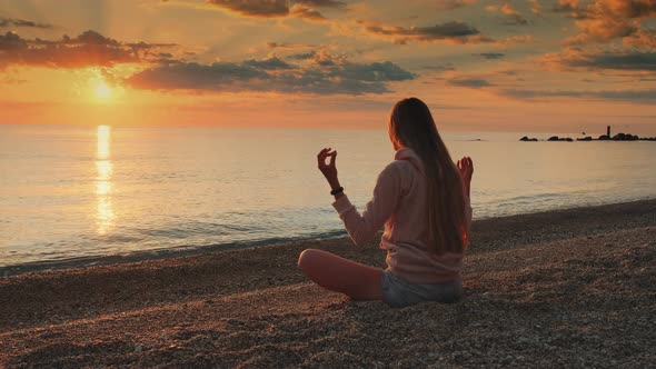 Woman Having Meditation Over the Sea Before Sunset