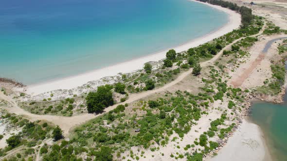 Aerial over crystal clear turquoise waters at Binh Tien Beach in Vietnam.