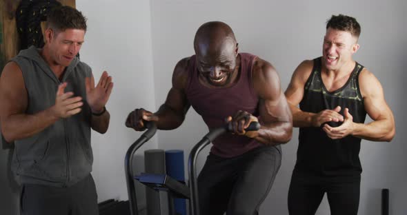 Diverse group of three fit men cross training inside gym