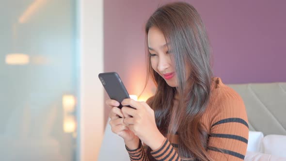 Young asian woman use smart phone in room