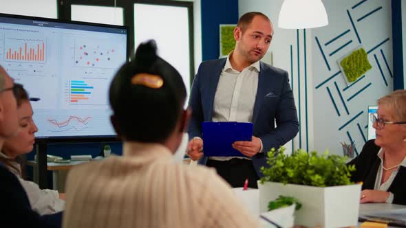 Business Leader Presenting Company Strategy to Diverse Team Using Digital Whiteboard