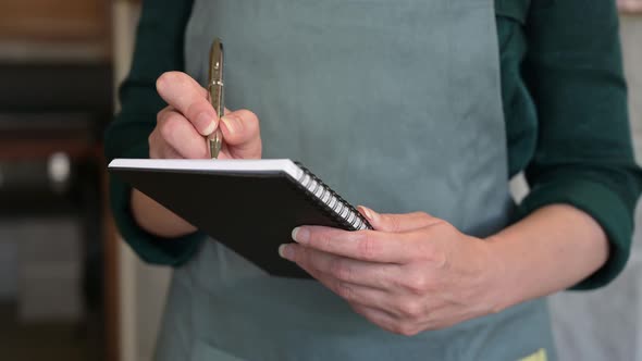 close-up adult woman waiter with notepad in restaurant takes order,.