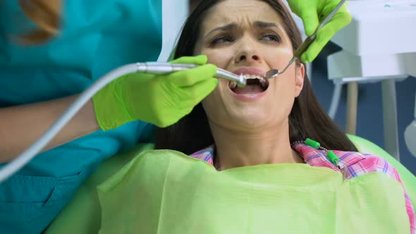 Female Patient Scared of Dental Drill, Painful Procedure, Sensitive Teeth