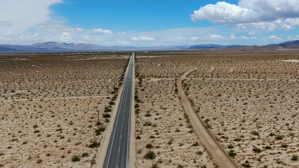 Aerial View of Endless Desert Straight Dusty Asphalt Road in Joshua Tree Park. USA.