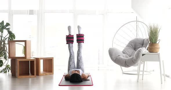 Fitness black woman in sportswear practicing  exercise with ankle weight.