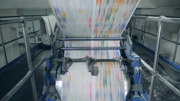 Newspaper Sheets Rolling on a Conveyor