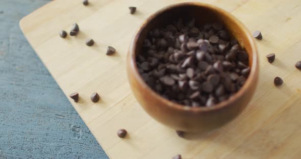 Video of close up of bowl with organic chocolate chip on wooden background