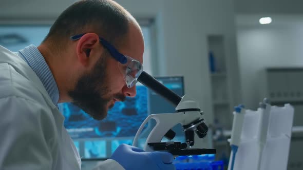 Man Research Scientist Looking at Samples Under Microscope