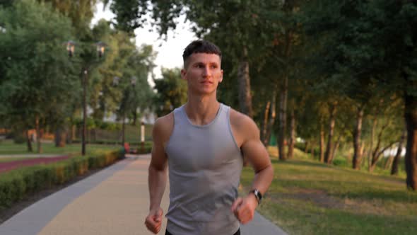 Athletic Man with Muscular Body Running in the Evening Outdoor Facing Sundown Motivation