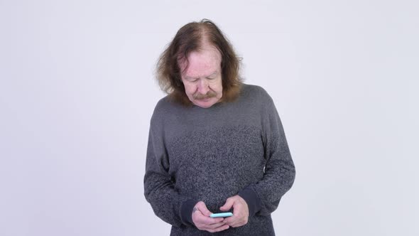 Stressed Senior Man with Mustache Using Phone and Getting Bad News