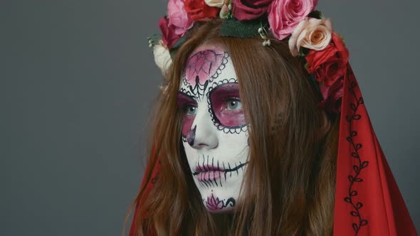 girl with Halloween makeup, sugar mexican skull on a gray background