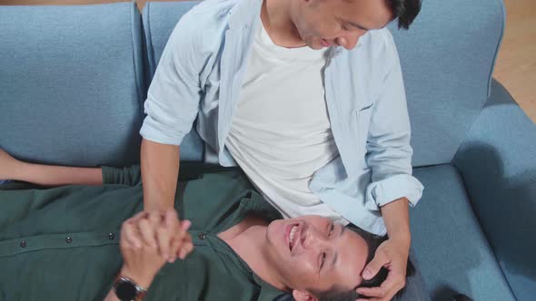 Young Asian Gay Couple Spend Time At Home. Two Happy Man In Love Lie Down On Sofa. Lgbt Relationship