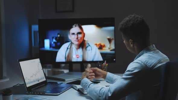 Back View of Young Man Making Video Call with Head Doctor About Your Health