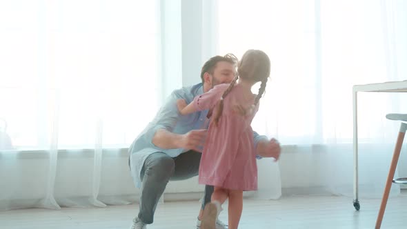 Young father hugging little daughter in home interior