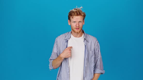 Redhead Man Turns Head Looking to Sides on Blue Background