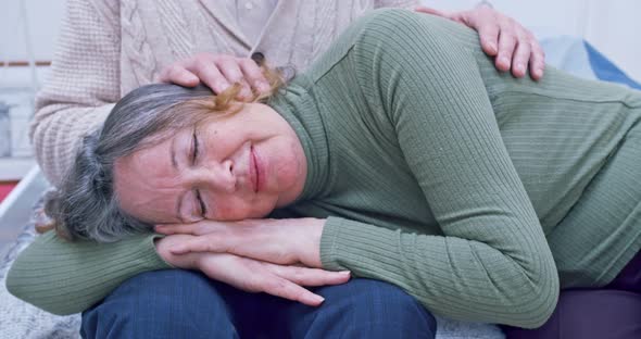 Portrait of a Sleeping Elderly Woman Sleeping in the Arms of Her Old Husband Who Strokes Her Head