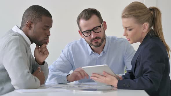 Male and Female Businessperson Having Discussion While Using Tablet