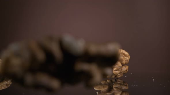 Falling Down Walnut Kernels on a Brown Background