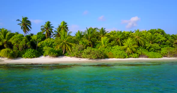 Daytime aerial tourism shot of a paradise sunny white sand beach and blue water background in 4K