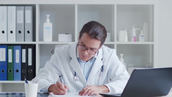 Professional medical doctor working in hospital office using computer technology.