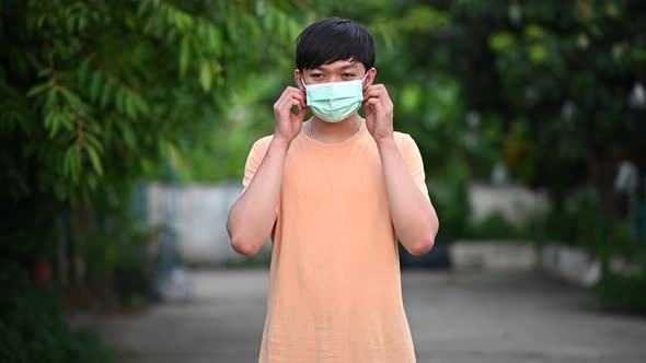 A teenage man taking off a medical mask.Slow motion footage.