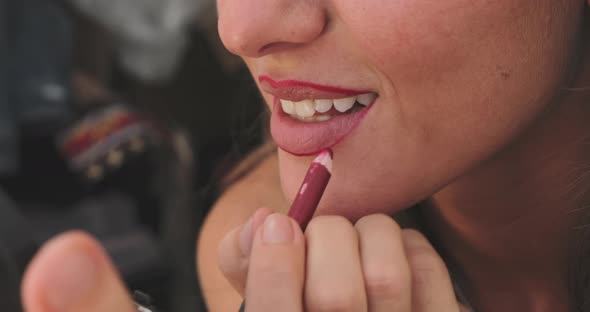 Close Up Slowmotion Footage of How a Girl with a Burgundy Pencil for Makeup Outlines the Contour of