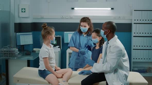 Cheerful Nurse and Medic Giving Highfive to Small Child