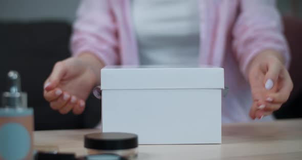 Close Up View of Female Hands Unpacking Present. Crop View of Girl Open White Box Standing on Table