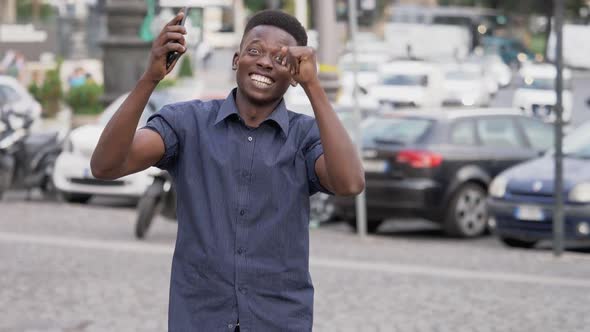 good news, joy, happiness.Young black African man rejoicing in the street