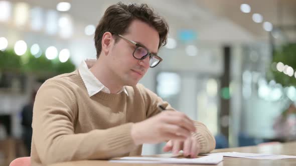 Man Failing to Write on Paper