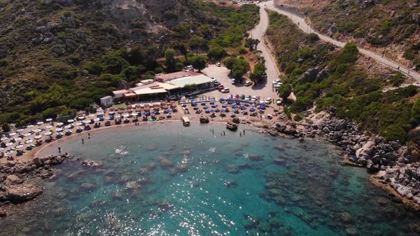 Aerial view of Anthony Quinn Bay with tourists swimming in the azure waters of the Mediterranean Sea