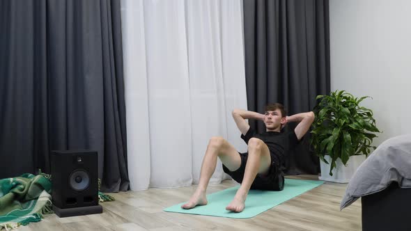 Fit male massages spine muscles using fascia roll. Stretching concept