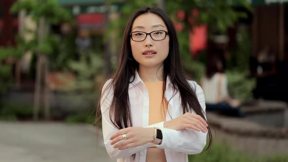 Young Asian Woman in Eyeglasses Smiling at Camera Looking Posing at Street