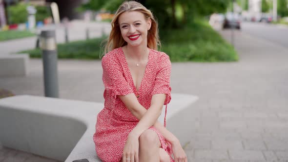 Happy Young Woman Sitting on Bench