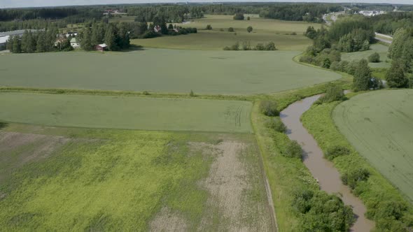 Slow aerial view of the Keravanjoki River in Finland near Kerava with the countryside and motorway i