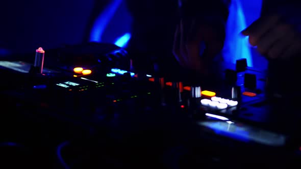 Close-up of DJ Hands Working on the Remote Control at Night Club.