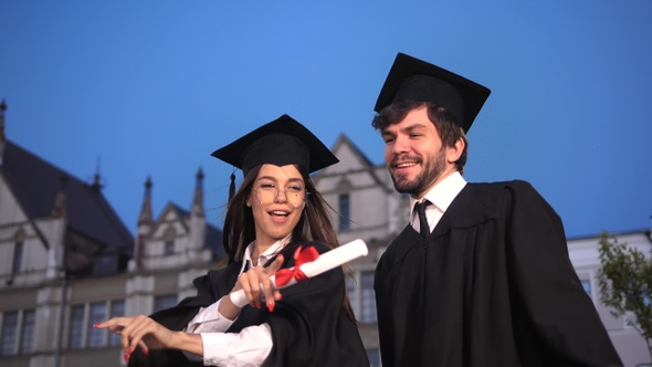 Happy young graduates dancing and celebrating graduation