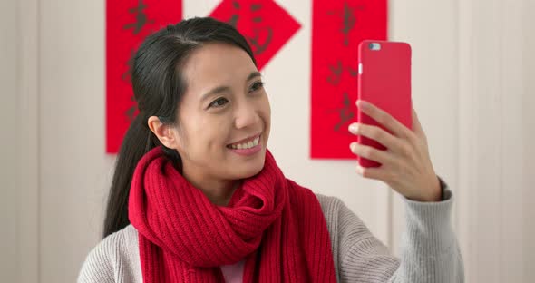 Chinese woman taking selfie and holding with red packet in lunar new year holiday